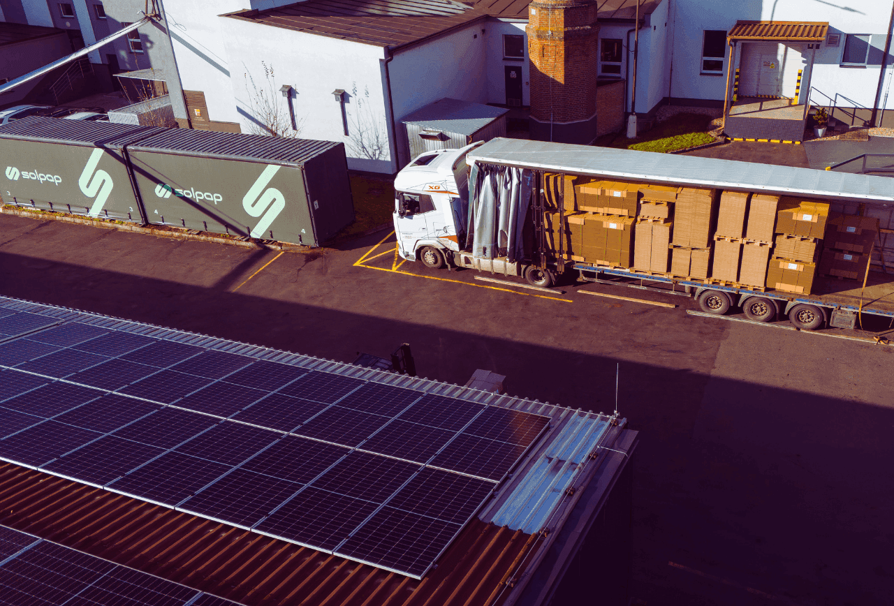 Krabice a obaly na míru: jak významně snížit logistické náklady? 8 Nakládka kartonových obalů na kamion v areálu solpap, v popředí střešní fotovoltaické panely.