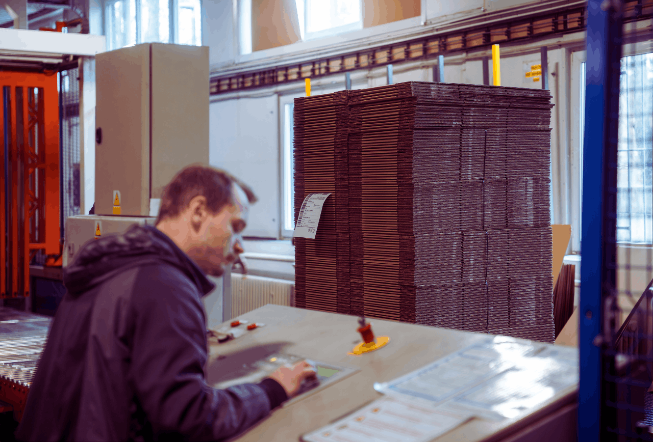 Nechte si rozebrat krabici. Možná balíte zbytečně špatně 1 Pracovník ve výrobní hale kontroluje stoh vyseknutých kartonových obalů z vlnité lepenky.