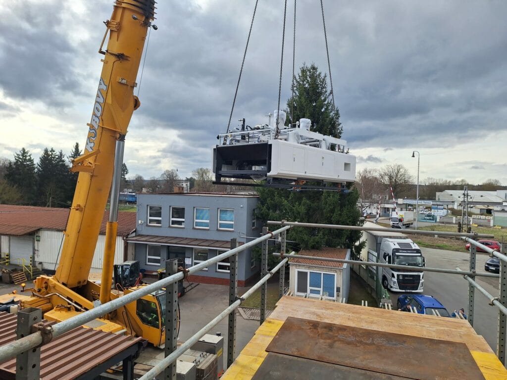 Manipulace s aplikátorem pásky ts-1450c3 jeřábem při přesunu na místo instalace